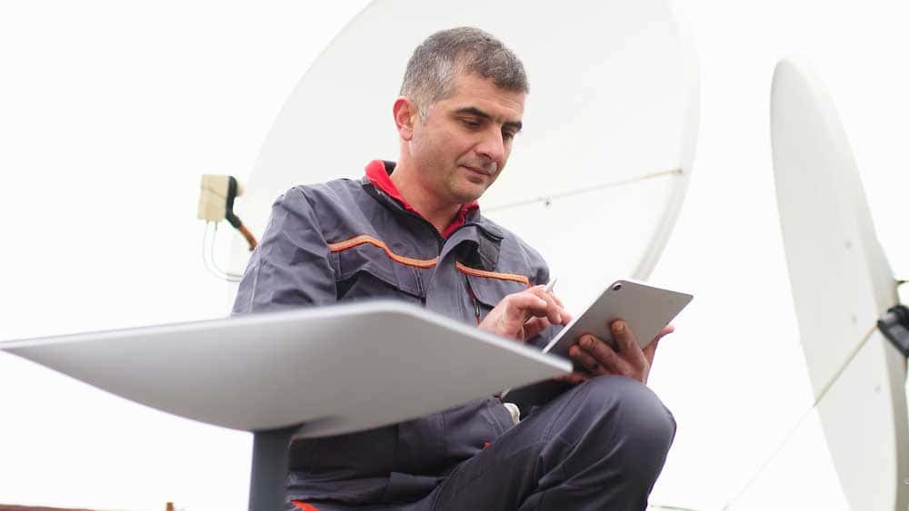 A man next to a Starlink Dish.