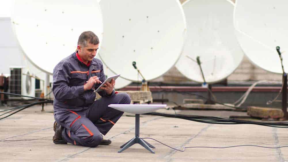An installer is setting up a Starlink Dish.